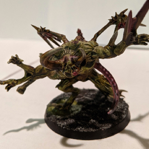A photo of a green horned chaos spawn with lots of extra arms.