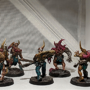A photo of five pox walkers from the back. They are all wearing ragged clothing and wielding makeshift melee weapons.