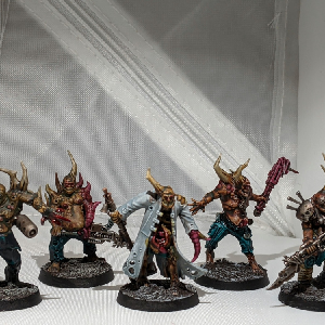 A photo of five pox walkers from the front. They are all wearing ragged clothing and wielding makeshift melee weapons.